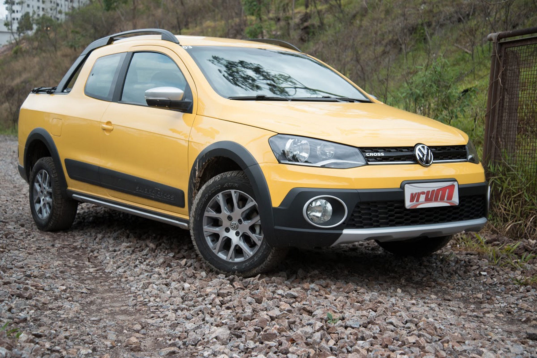 VW Saveiro Cross cabine dupla modelo 2015 amarela de frente estrada de terra