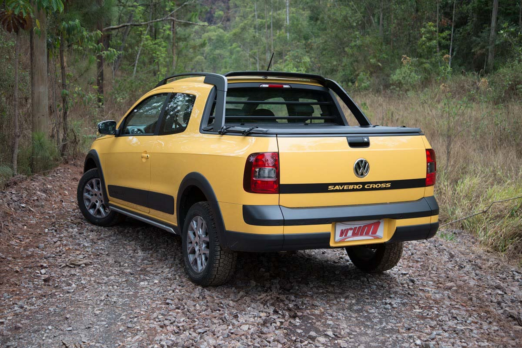 VW Saveiro Cross cabine dupla modelo 2015 amarela de traseira estrada de terra