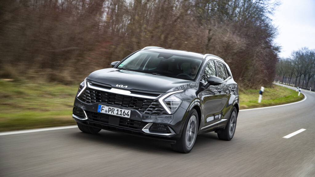 Kia Sportage 2022 preto de frente rodando em uma rodovia.