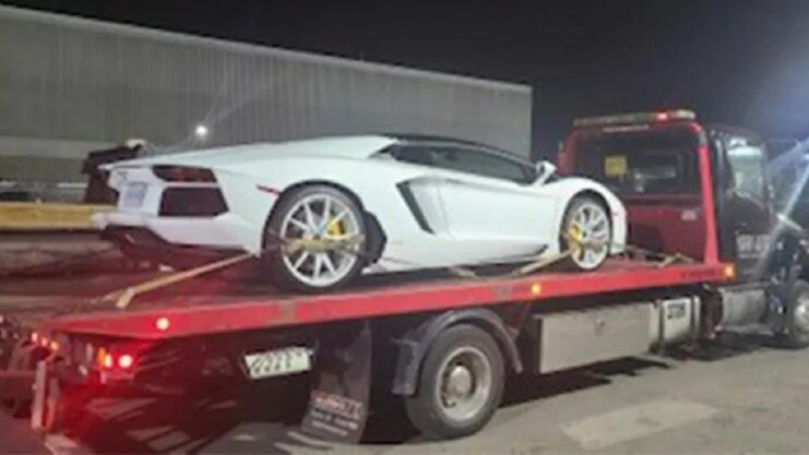 Lamborghini Aventador branco em cima de caminhão reboque, após ser apreendido por excesso de velocidade