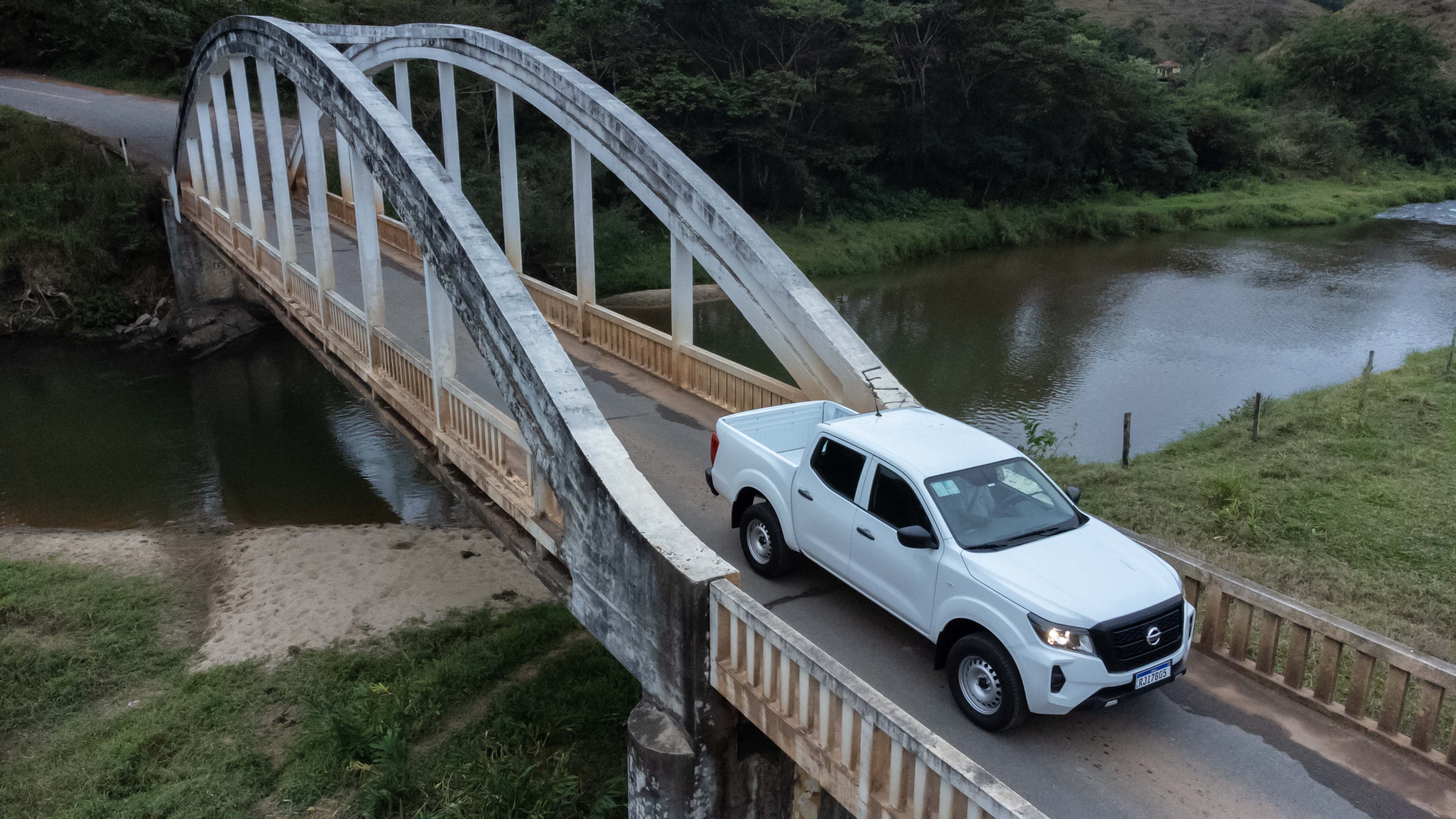Nissan Frontier S vista de lado atravessando uma ponte. 