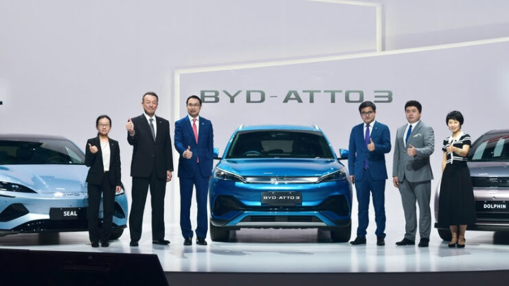 Estande da BYD com os três novos modelos elétricos e representantes da marca ao lado dos carros.