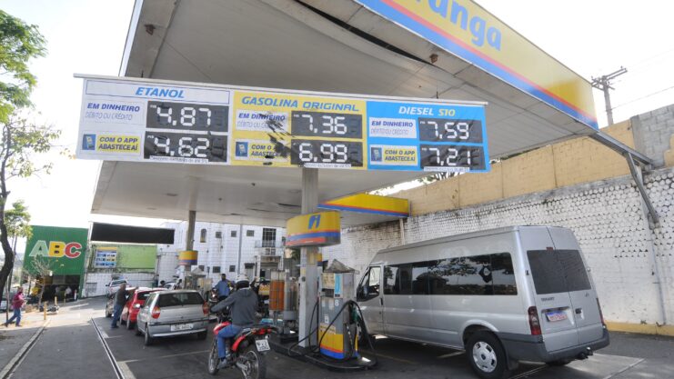 Posto de combustíveis Ipiranga com placa indicando preços de gasolina, etanol e diesel S10 em primeiro plano