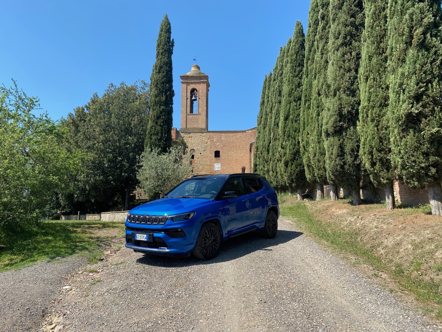 Jeep Compass 4xe híbrido plug-in azul de frente na Toscana pista de terra