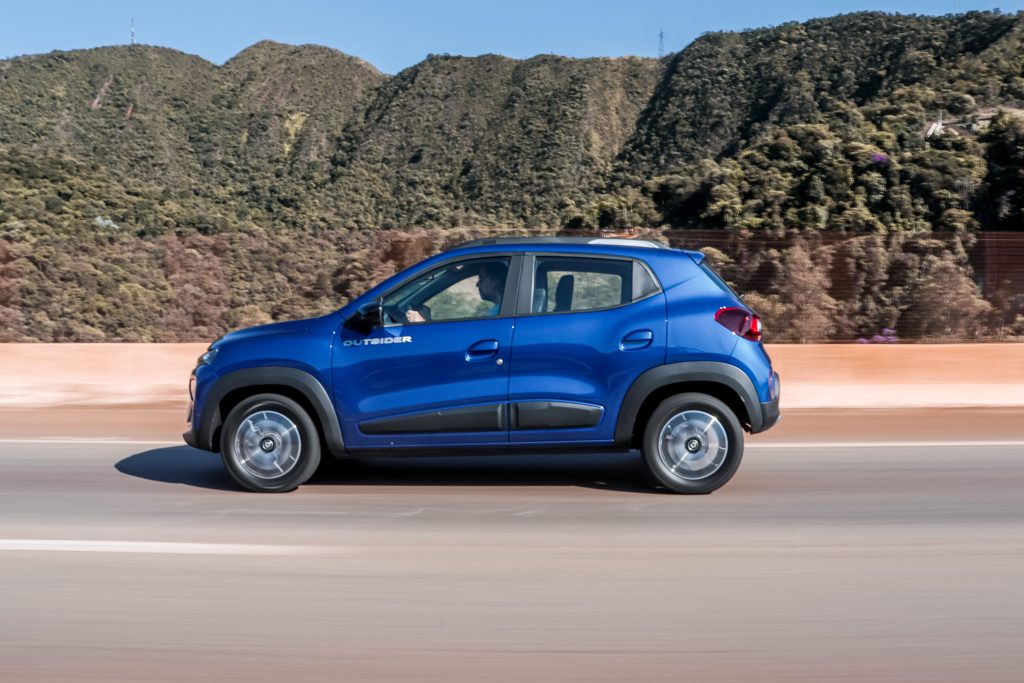 Renault Kwid azul de lado em movimento; hoje o modelo é o carro mais barato do Brasil.