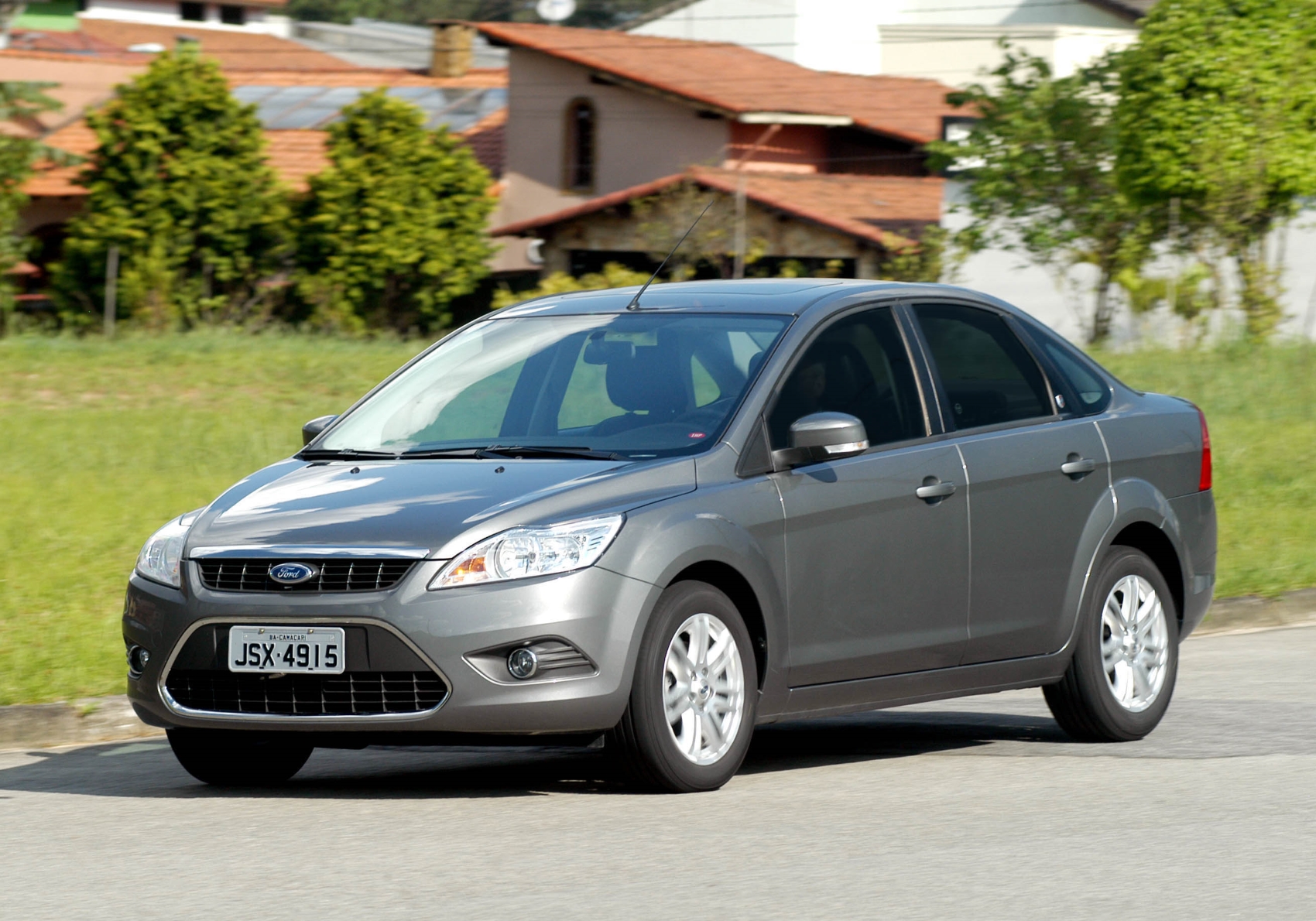 Ford Focus Sedan modelo 2011 cor prata no asfalto de frente