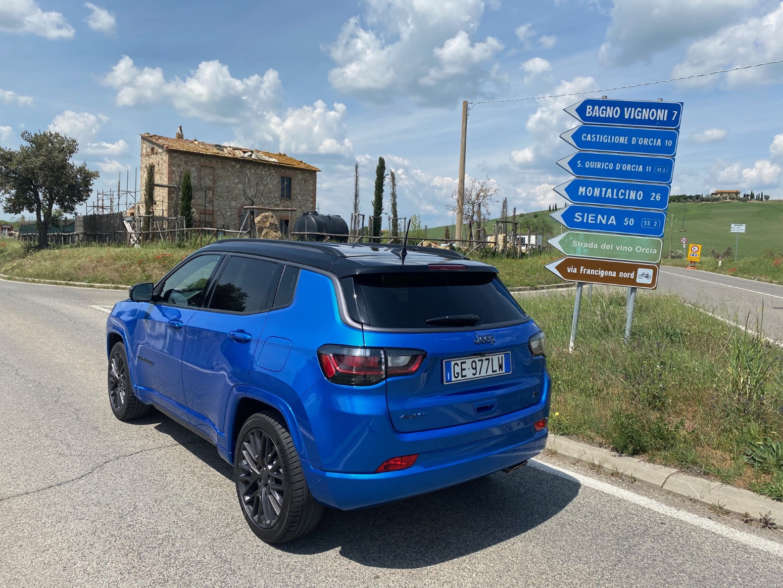 Jeep Compass 4xe híbrido plug-in azul de traseira na Toscana pista de terra