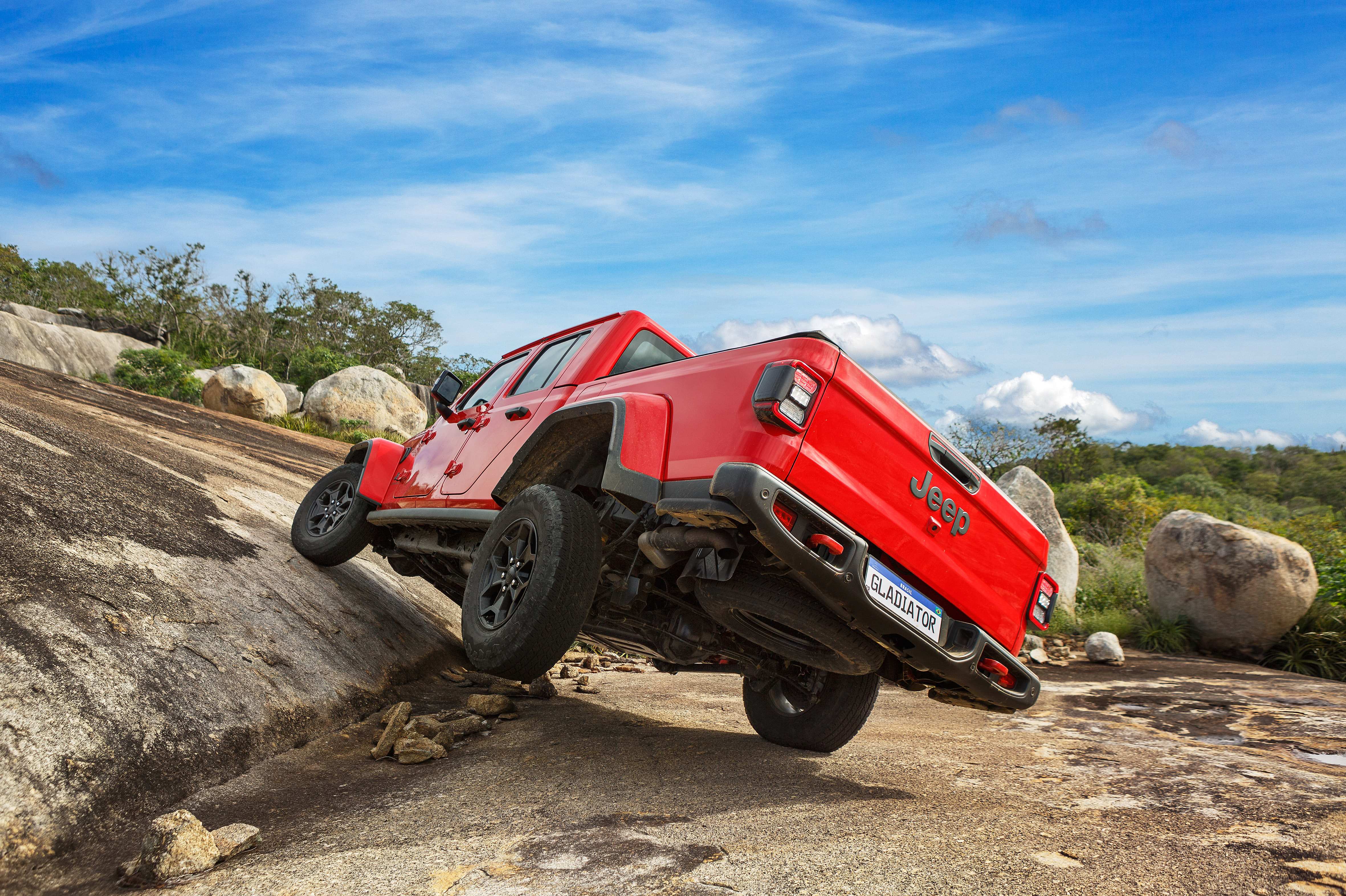 Jeep Gladiator Rubicon 2022 vermelho de traseira com uma roda no ar.