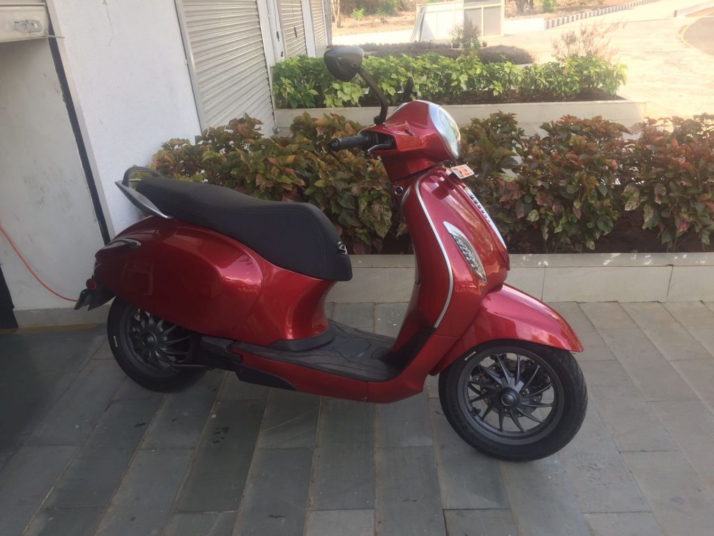 Bajaj Chetak vermelha vista de lado. scooter elétrico faz parte da lista de lançamentos 2023 da marca indiana.