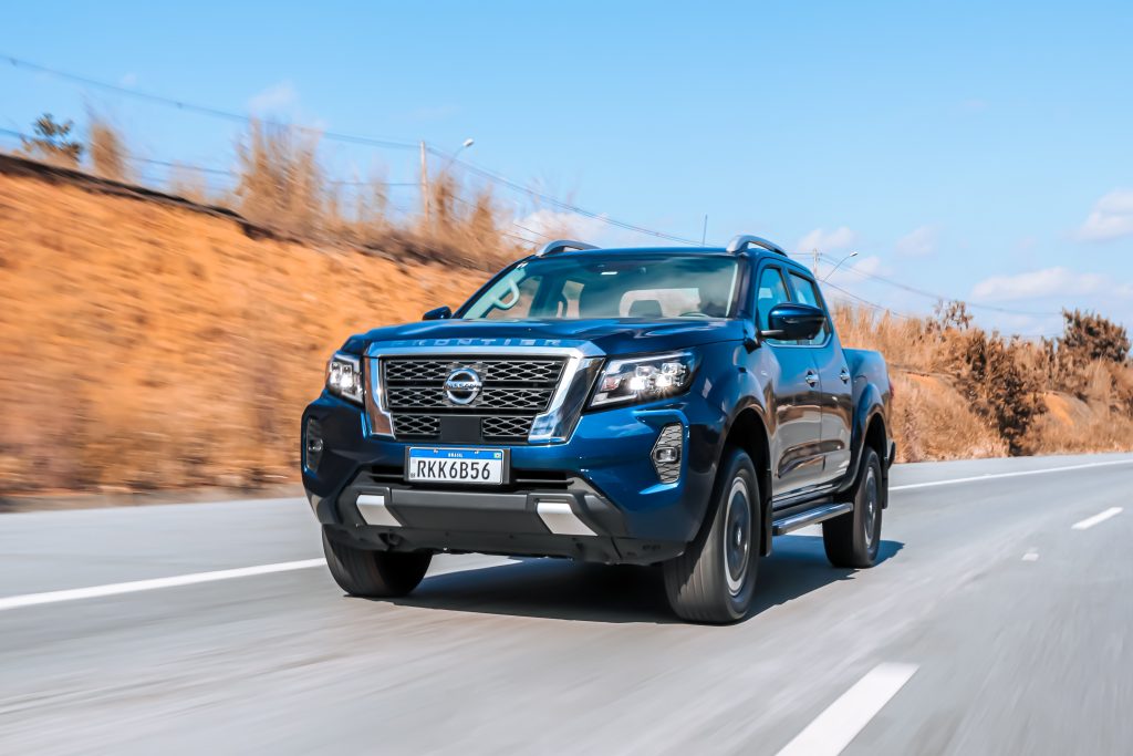 Nissan Frontier Platinum 2022 azul de frente em movimento na estrada.