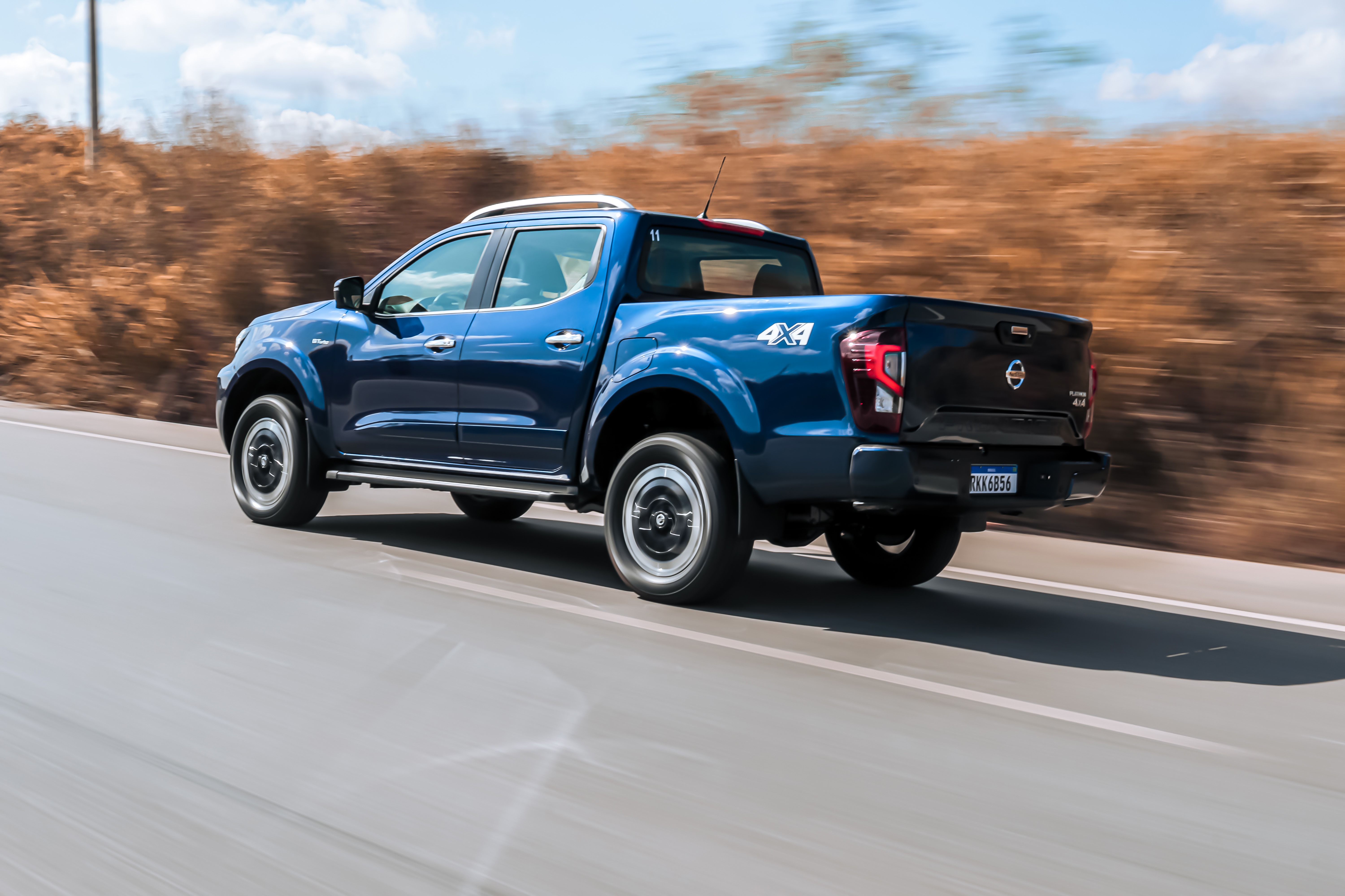 Nissan Frontier Platinum 2022 azul em movimento de traseira.