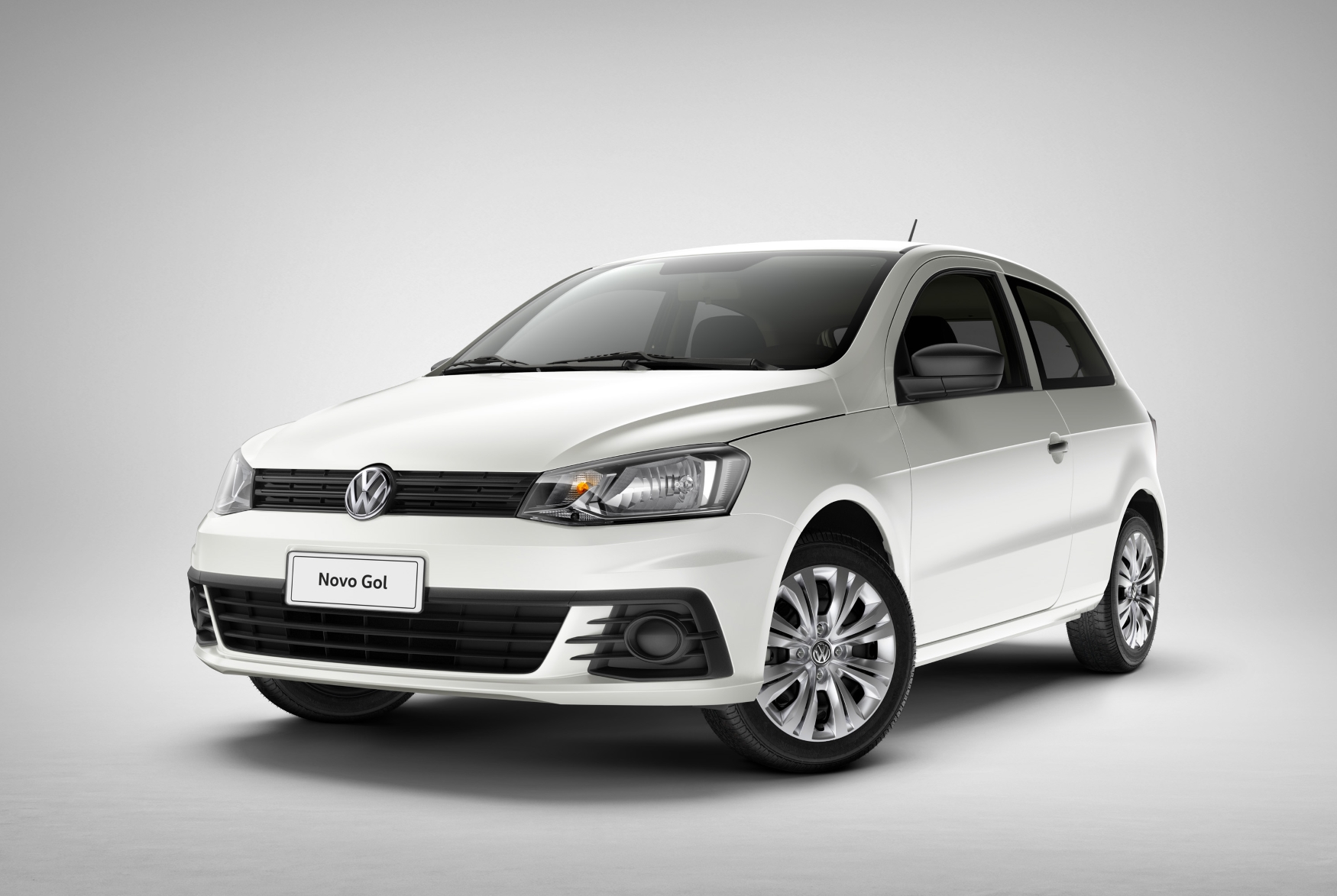 Volkswagen Gol branco duas portas modelo 2016 de frente no estúdio