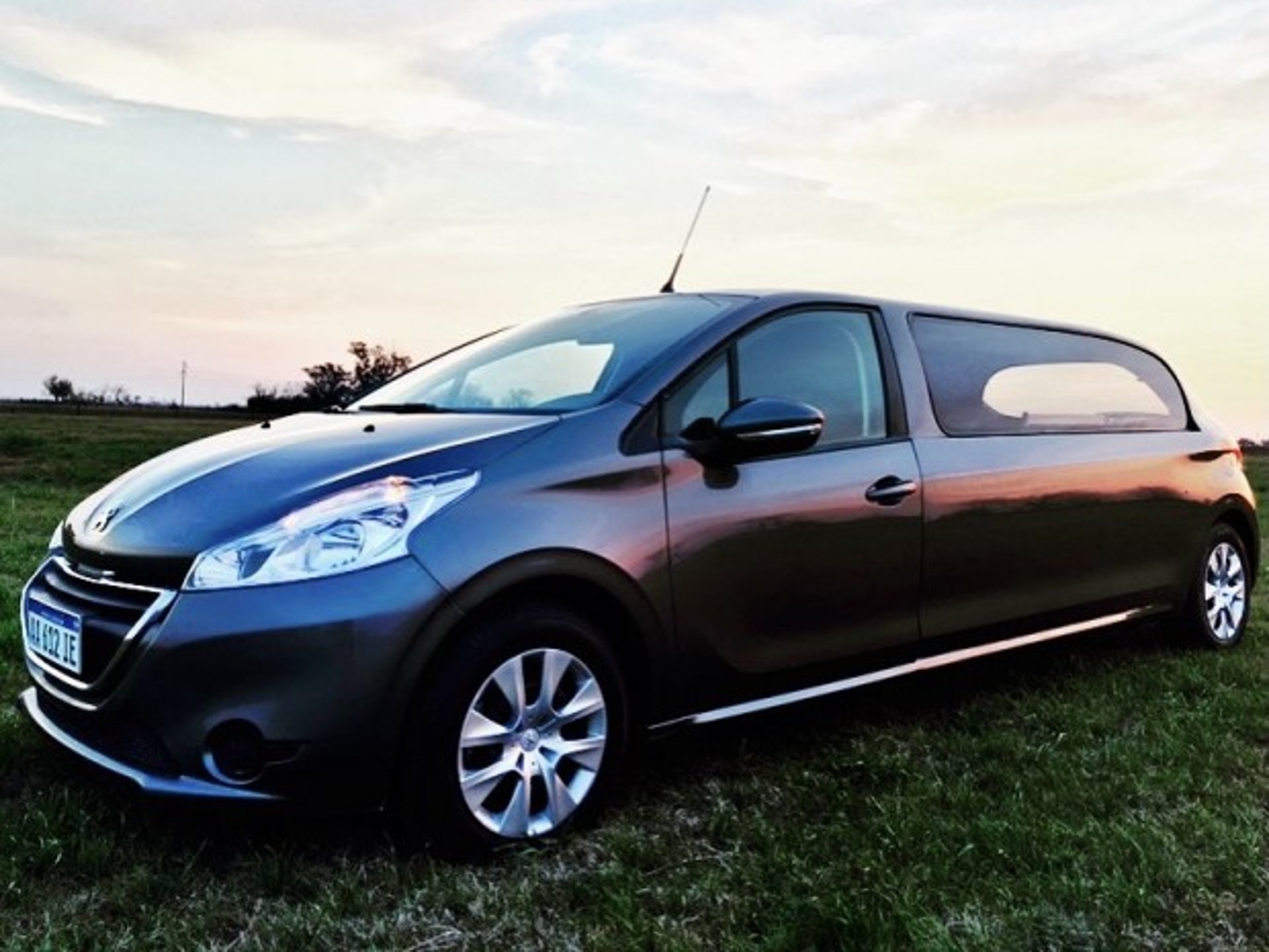 Carro funerário inspirado em uma antiga versão do Peugeot 208. Ele é visto da diagonal frontal. 