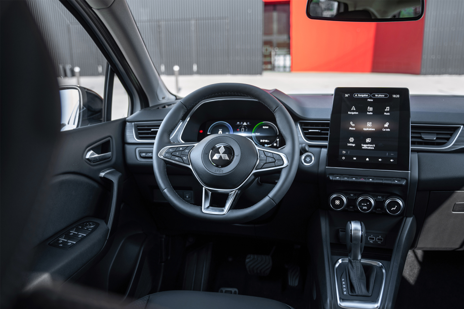 Inside, it shows the dashboard and steering wheel of the 2023 Mitsubishi ASX 