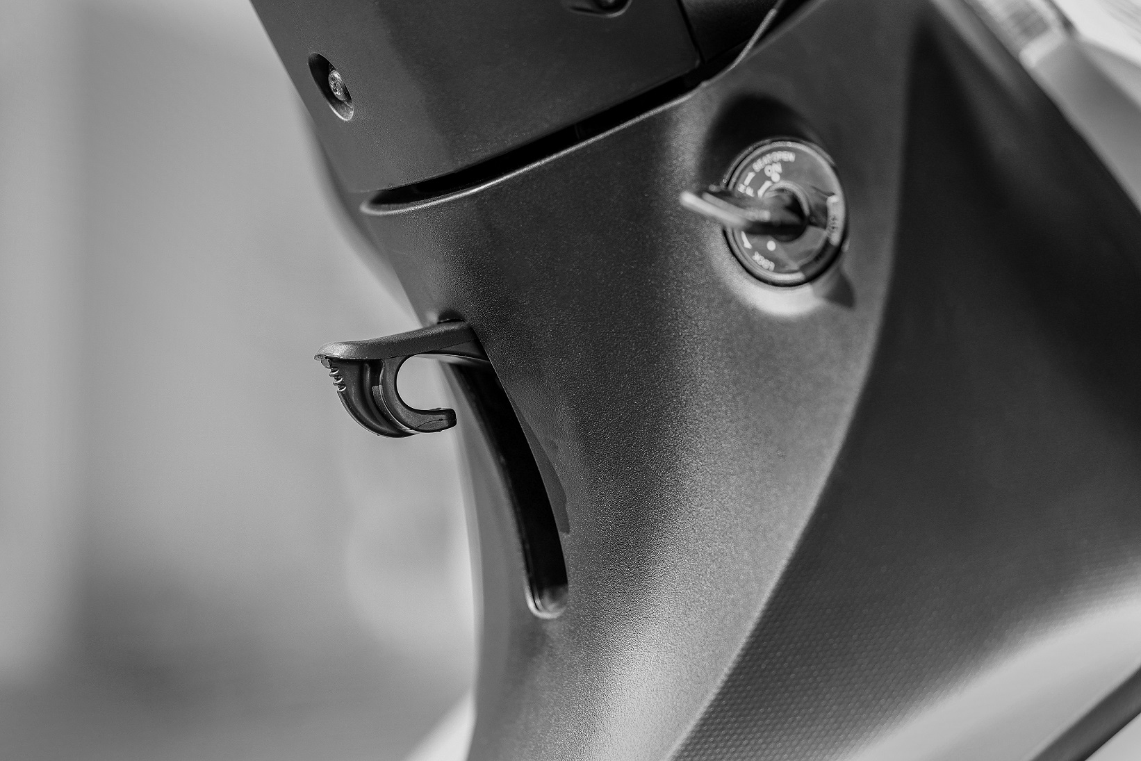 Detalhe do gancho para pendurar sacolas da Honda Biz 125 2023 prata fosco com preto