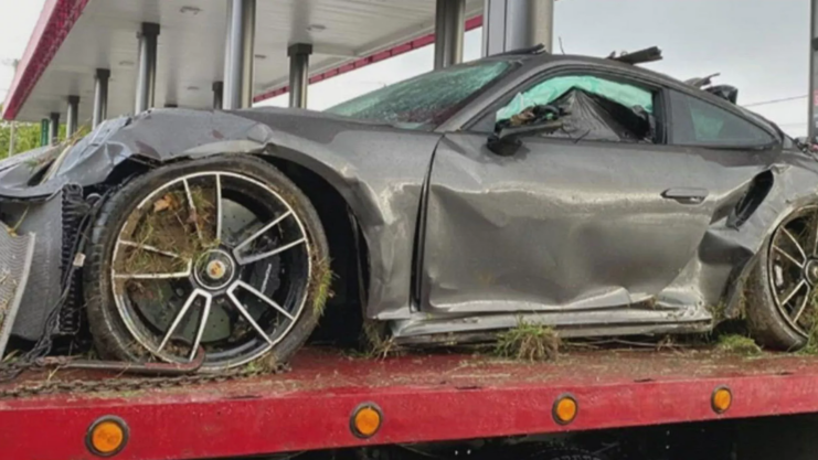 Image of Myles Garrett's Porsche 911 completely destroyed and dented after the accident.  She is seen from the side.