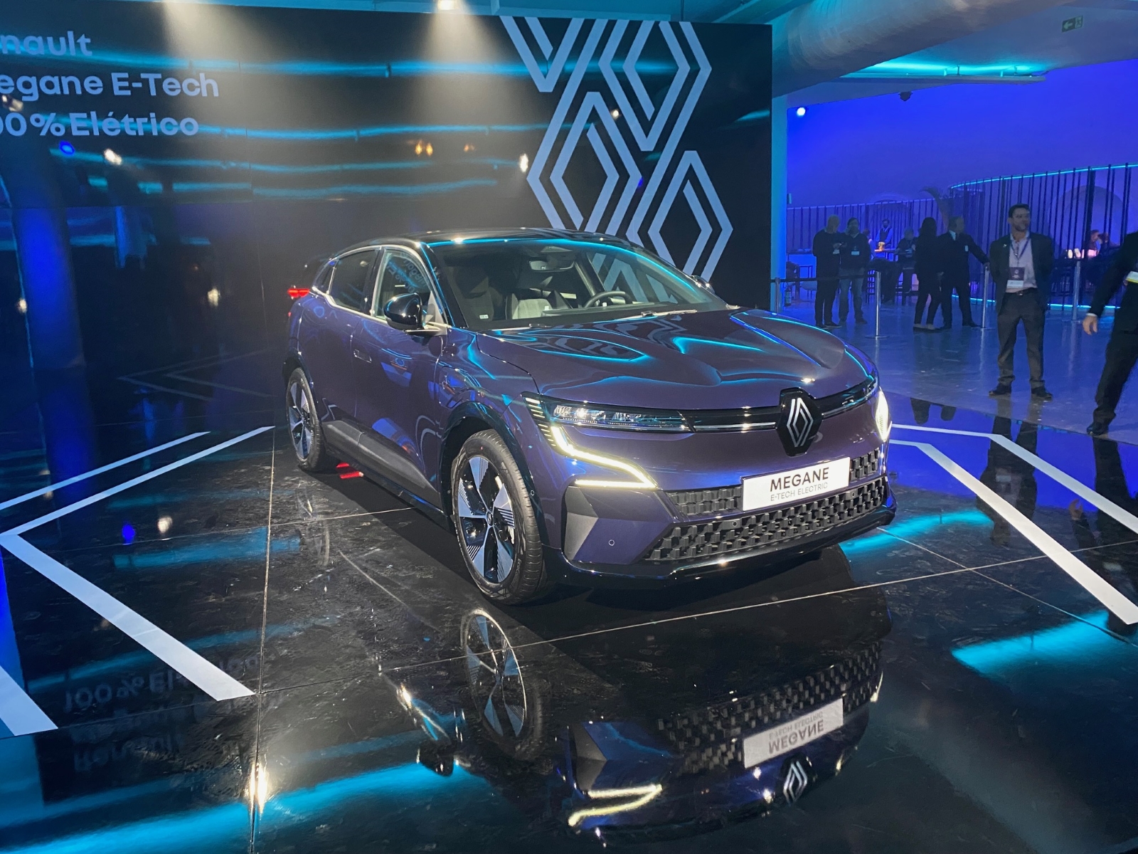 Renault Megane E-Tech 100% elétrico azul no estande da marca de frente; modelo está na lista de lançamento 2023 de SUVs elétricos e híbridos no Brasil.