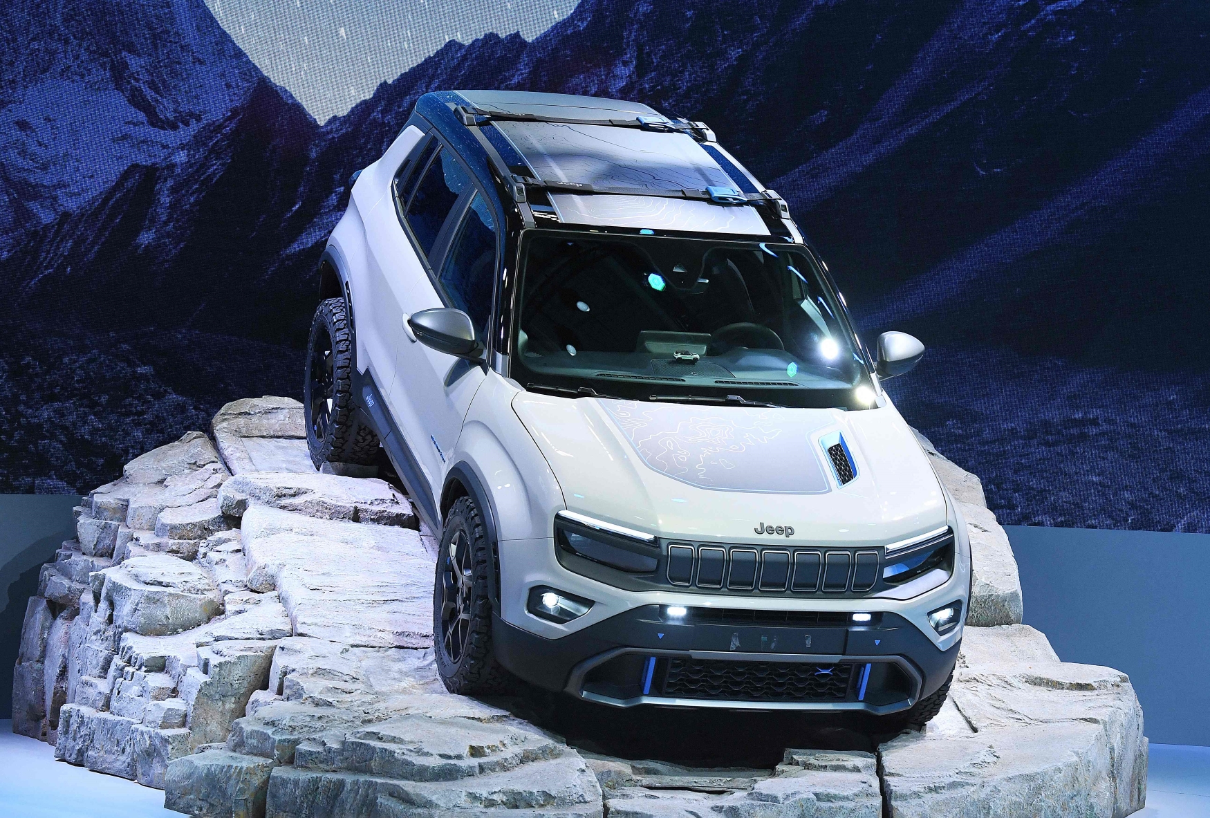 Salão de Paris 2022 Jeep Avenger 4xe concept branco de frente sobre pedra no estande da Jeep