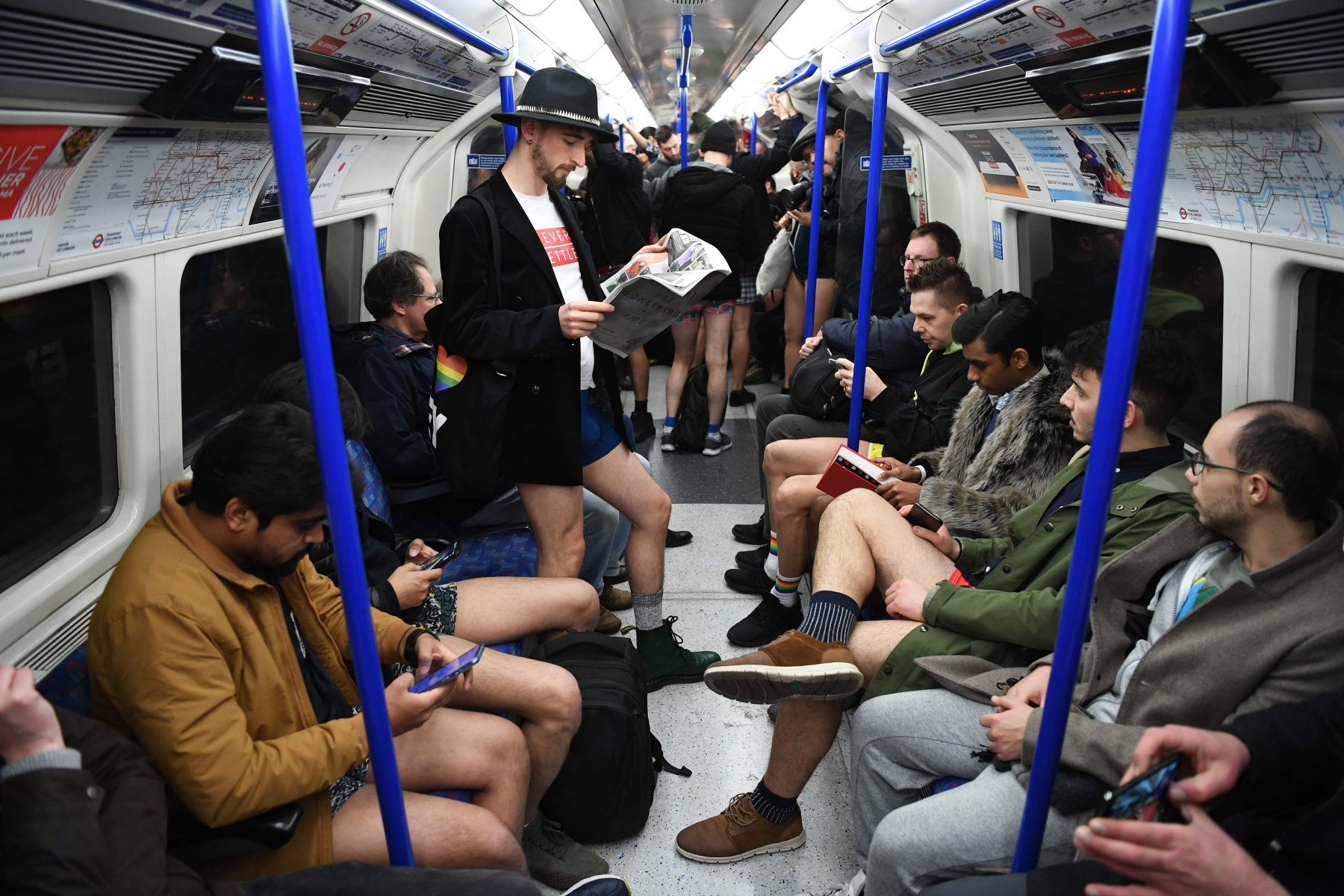 Metrô de Londres interior do vagão com pessoas sentadas e outras em pé