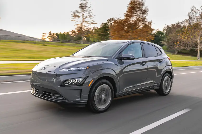 Hyundai Kona marrom visto da diagonal frontal em movimento na estrada.