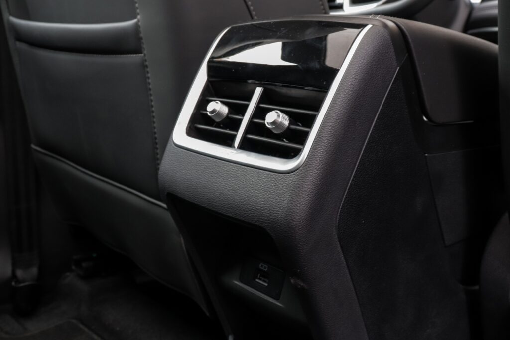 Caoa Chery Tiggo 5X Pro Hybrid modelo 2022 branco interior console com saída ar-condicionado e USB no asfalto