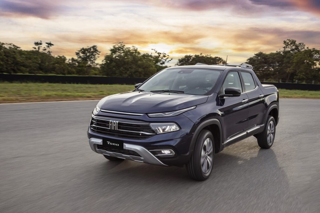 Fiat Toro azul visto da diagonal frontal em movimento na estrada. Picape será um concorrente para a Baby Hilux da Toyota. 