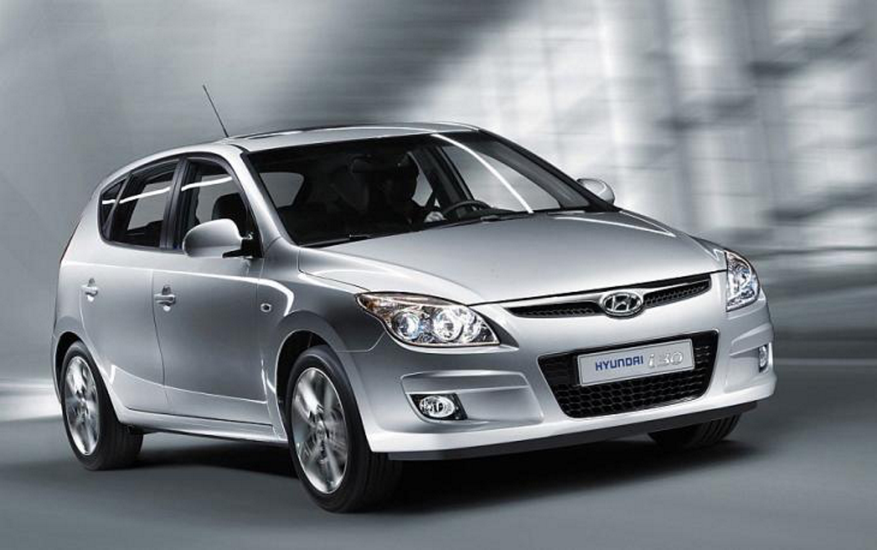 Hyundai i30 modelo 2009 prata de frente no asfalto