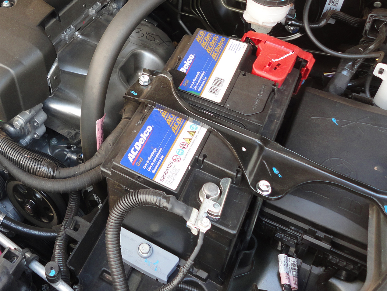 Bateria da marca AC Delco instalada em cofre de motor de carro