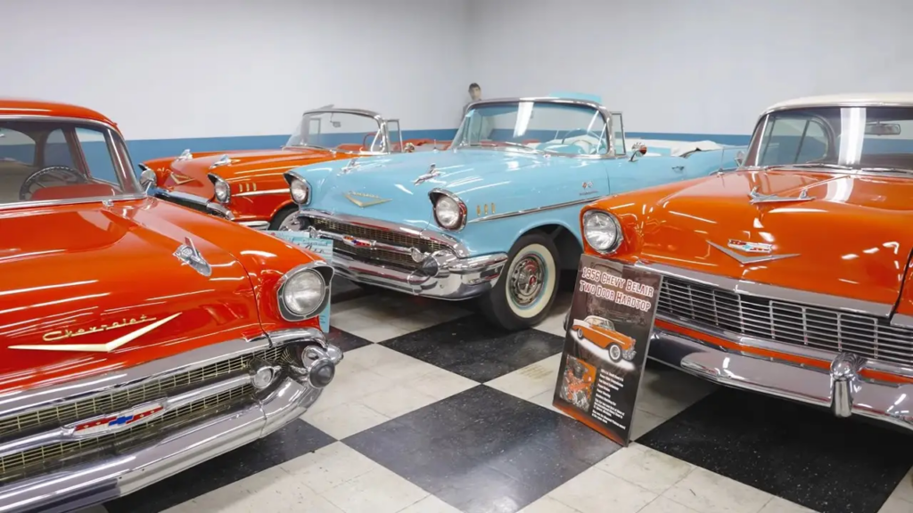 Modelos Chevrolet Bel Air vermelhos e azul estacionados na garagem.