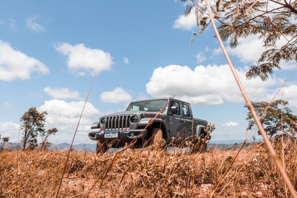 Jeep Gladiator Rubicon 3.6 V6 modelo 2022 cinza de frente na terra e mato estático