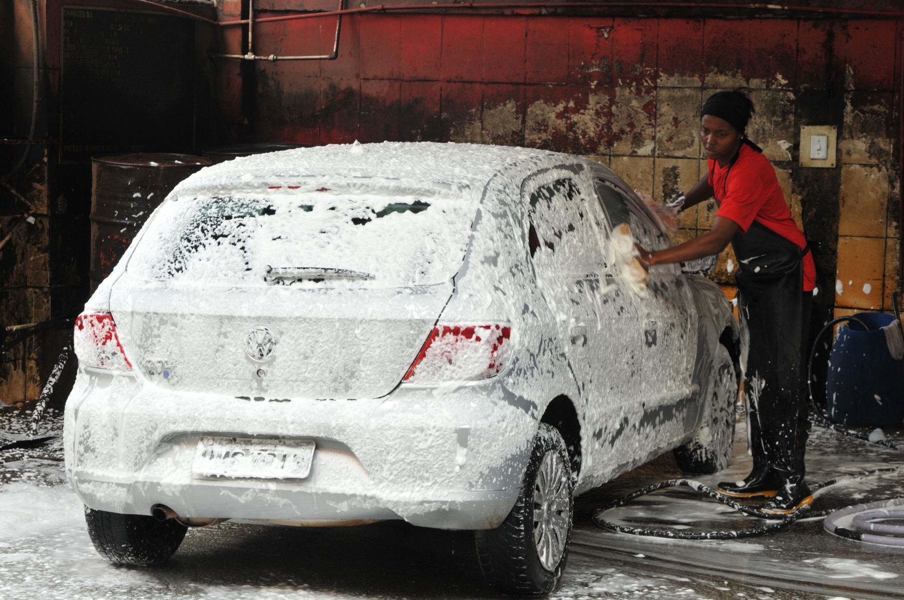 Lavagem de carro VW Gol prata em lavajato com espuma homem lavando