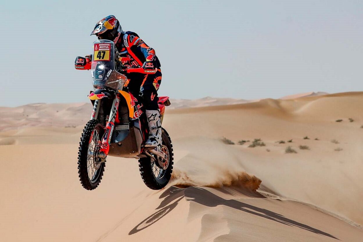 Rally Dakar 2023 KTM 450 Rally Factoring amarelo vermelho de frente pulando nas dunas deserto em movimento piloto argentino Kevin Benavides
