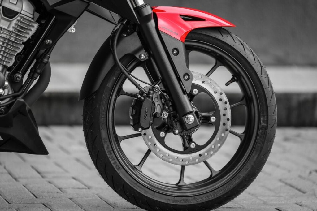 Honda CB 300F Twister modelo 2023 vermelho detalhe roda dianteira freio ABS estática no calçamento