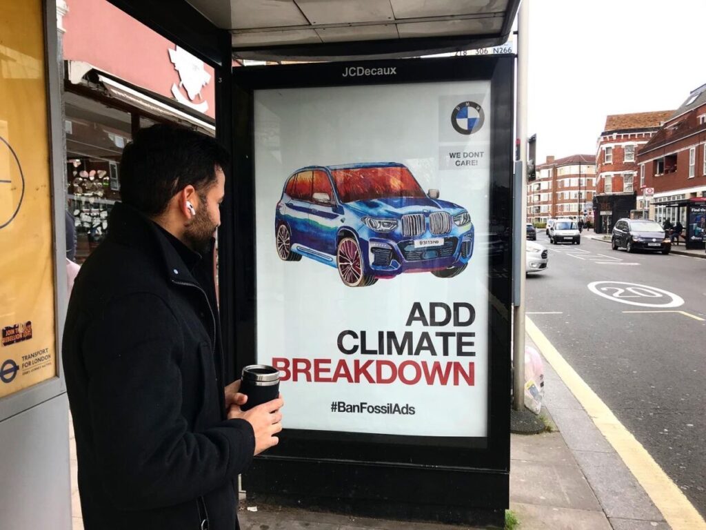 Outdoor subvertido com mensagem de ataque à BMW. A frase diz "Colapso climático".