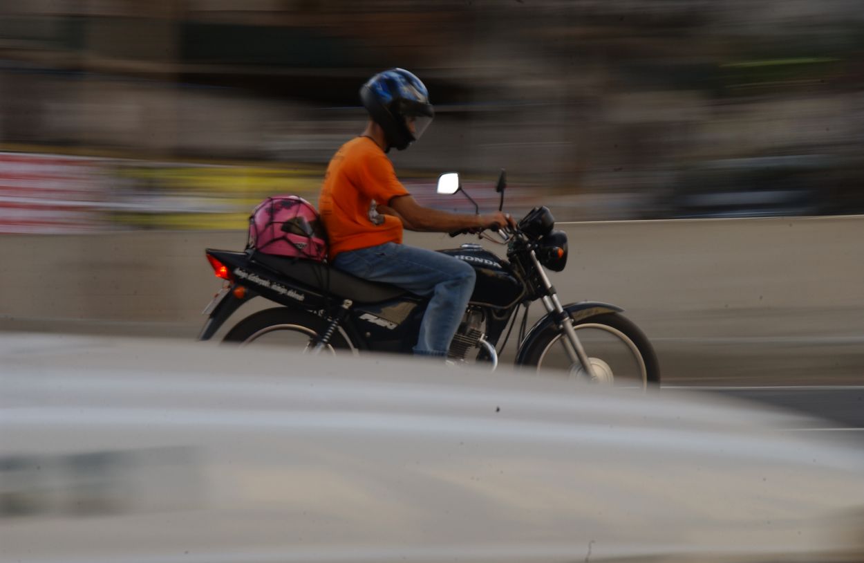 Motociclista transita de capacete na avenida Cristiano Machado, em Belo Horizonte