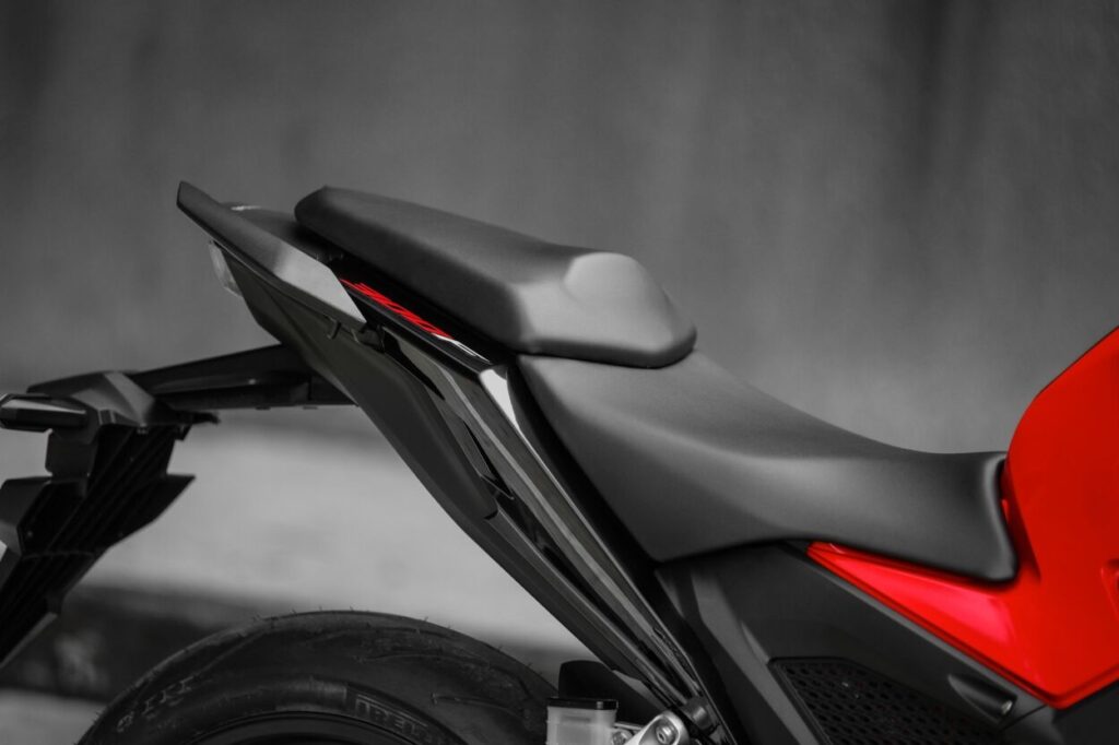 Honda CB 300F Twister modelo 2023 vermelha detalhe do banco em dois níveis estática no estúdio