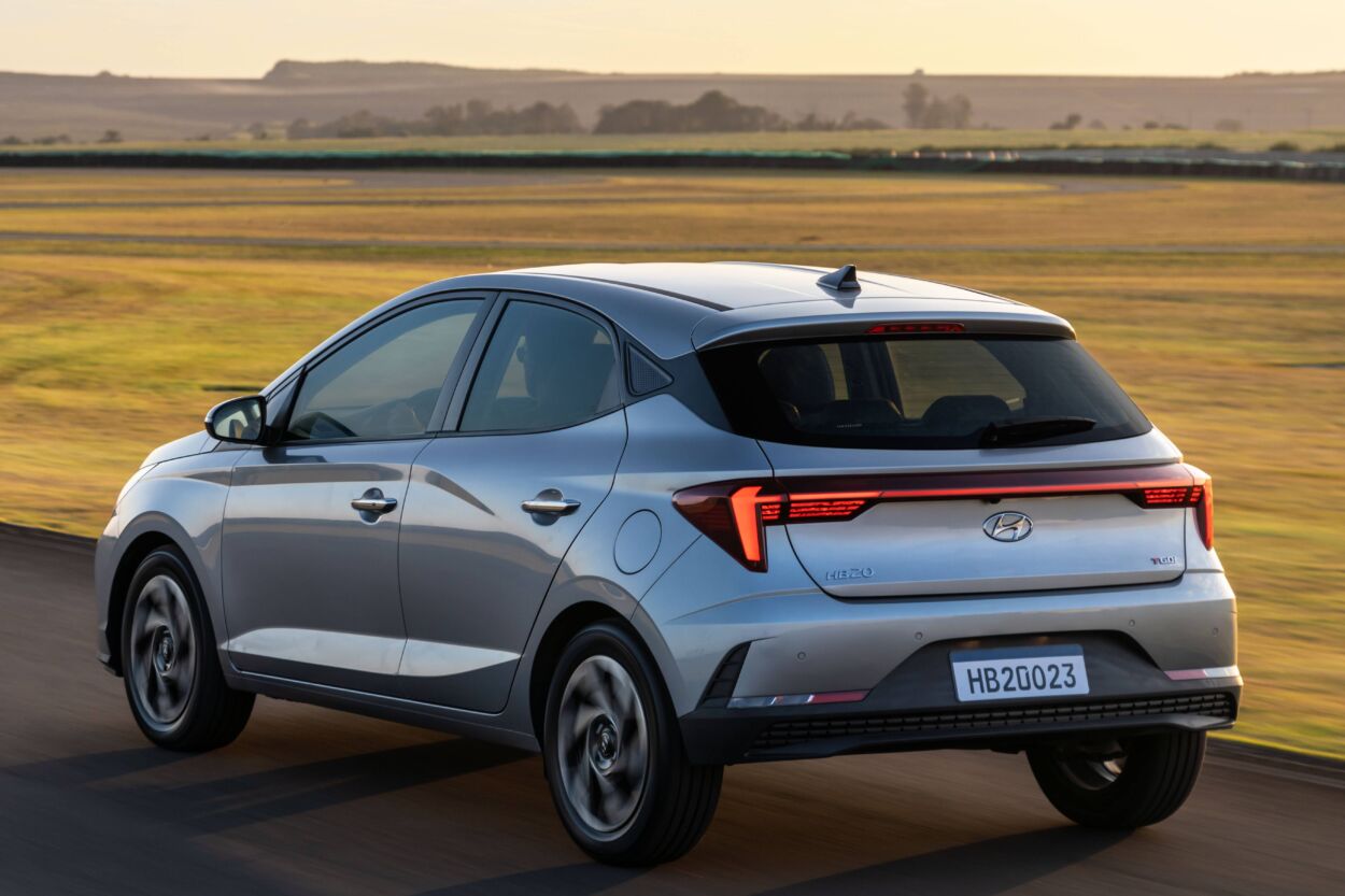 Hyundai HB20 2023 hatch cinza de traseira em movimento. Modelo está entre os carros populares mais baratos do Brasil em junho de 2023.