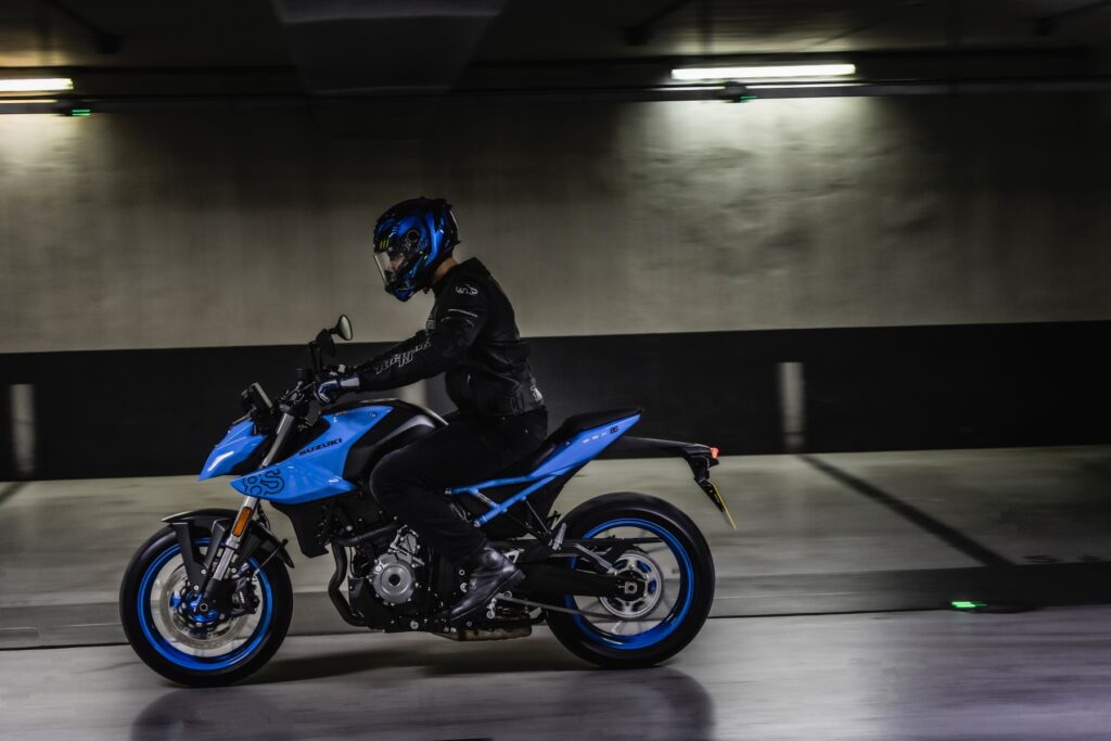 Suzuki GSX-8S modelo 2023 azul e preto de lateral em movimento no asfalto