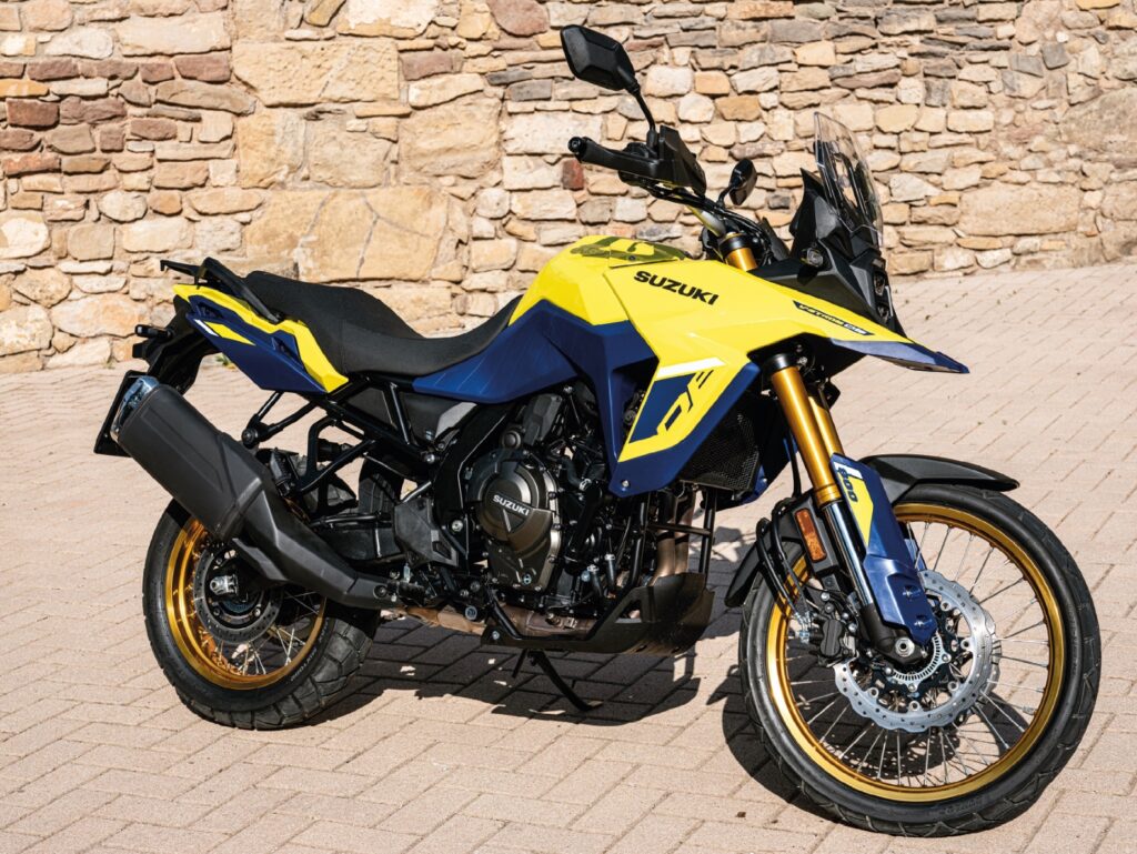 Suzuki V-Strom 800 modelo 2023 amarela de lateral no calçamento