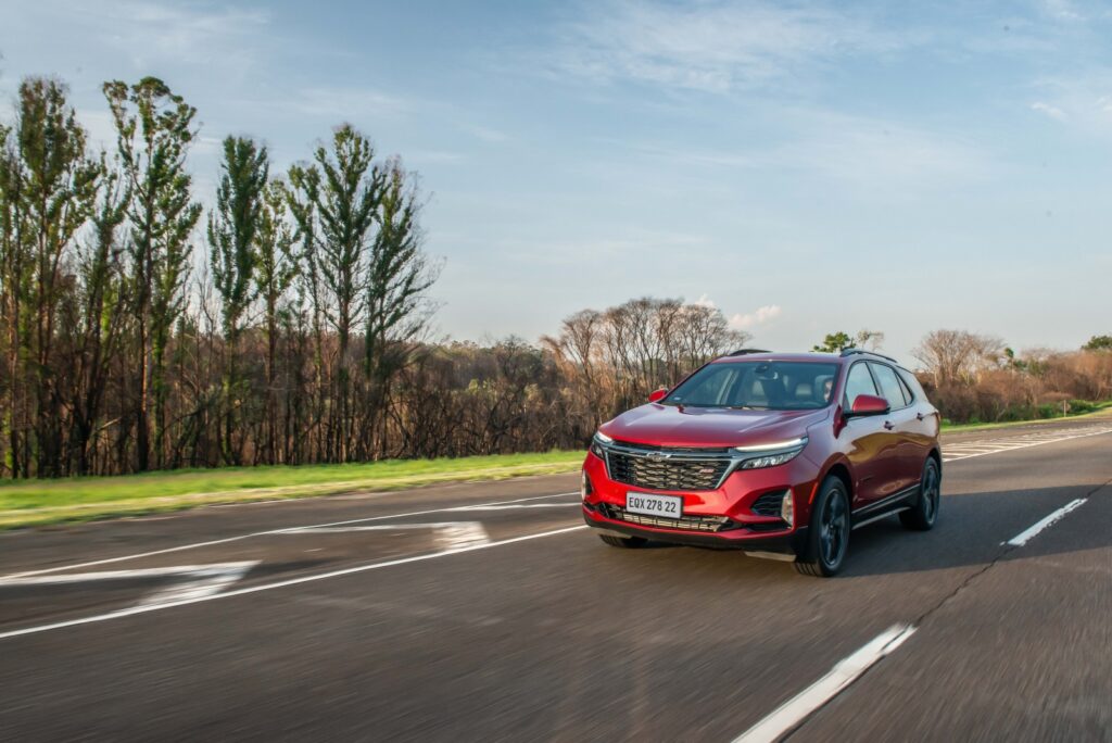 Equinox RS vermelho visto da diagonal frontal em movimento na estrada; para matéria sobre versões especiais da Chevrolet.