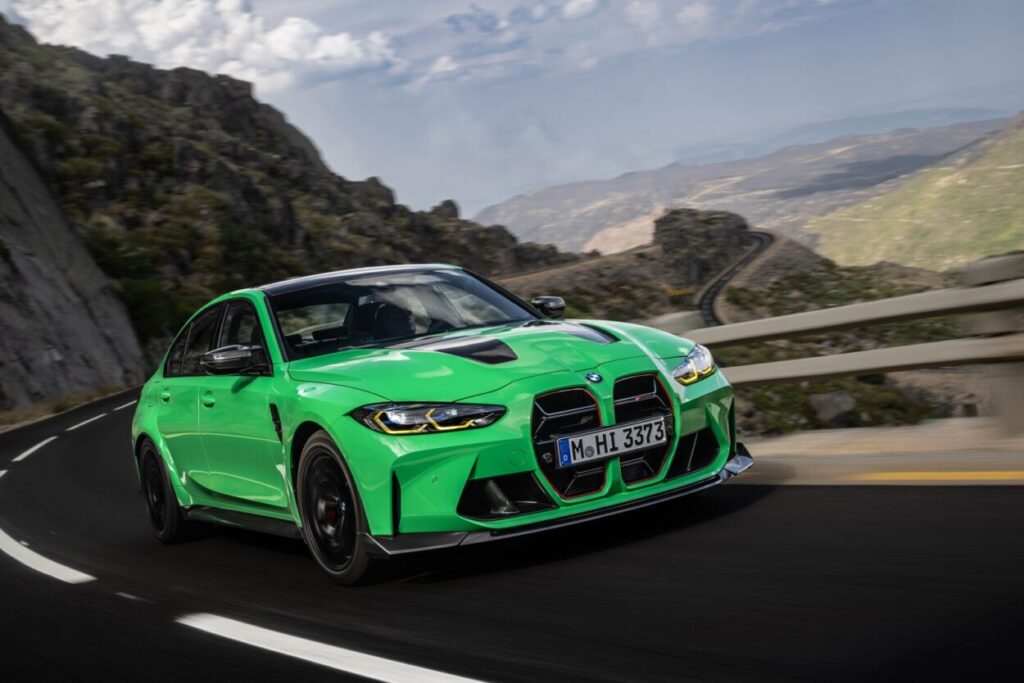 Novo BMW M3 CS 2024 verde visto da diagonal frontal em movimento na estrada.