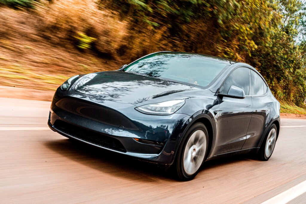 Tesla Model Y preto em movimento na estrada.