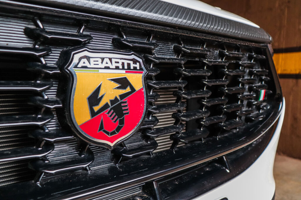 Grade central do Pulse Abarth em preto brilhante, em formato de colméia com o Brasão da escuderia abarth em destaque