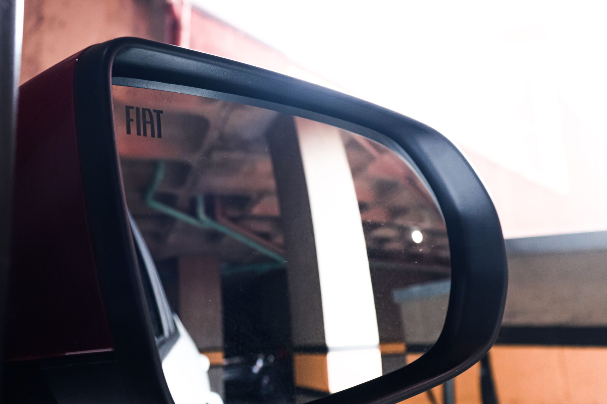 Imagem do espelho retrovisor do Pulse Abarth com o simbolo da Fiat no canto superior esquerdo