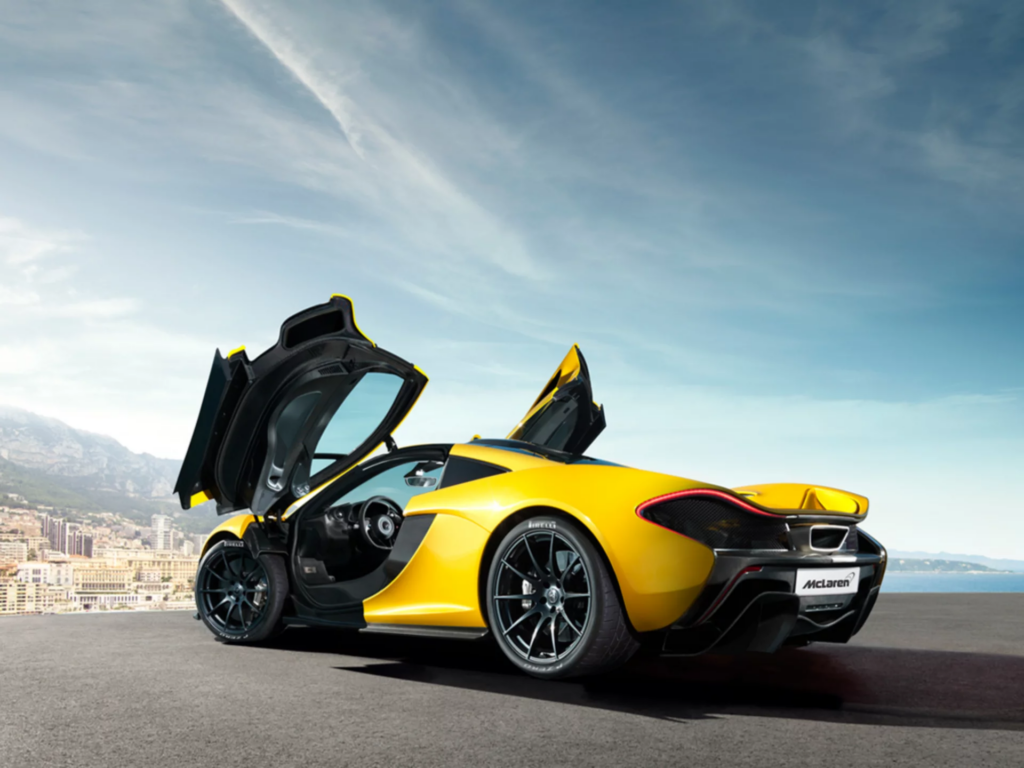 McLaren p1 amarelo visto de trás com as portas abertas para cima. O design do modelo não foi criado por Inteligência Artificial. 