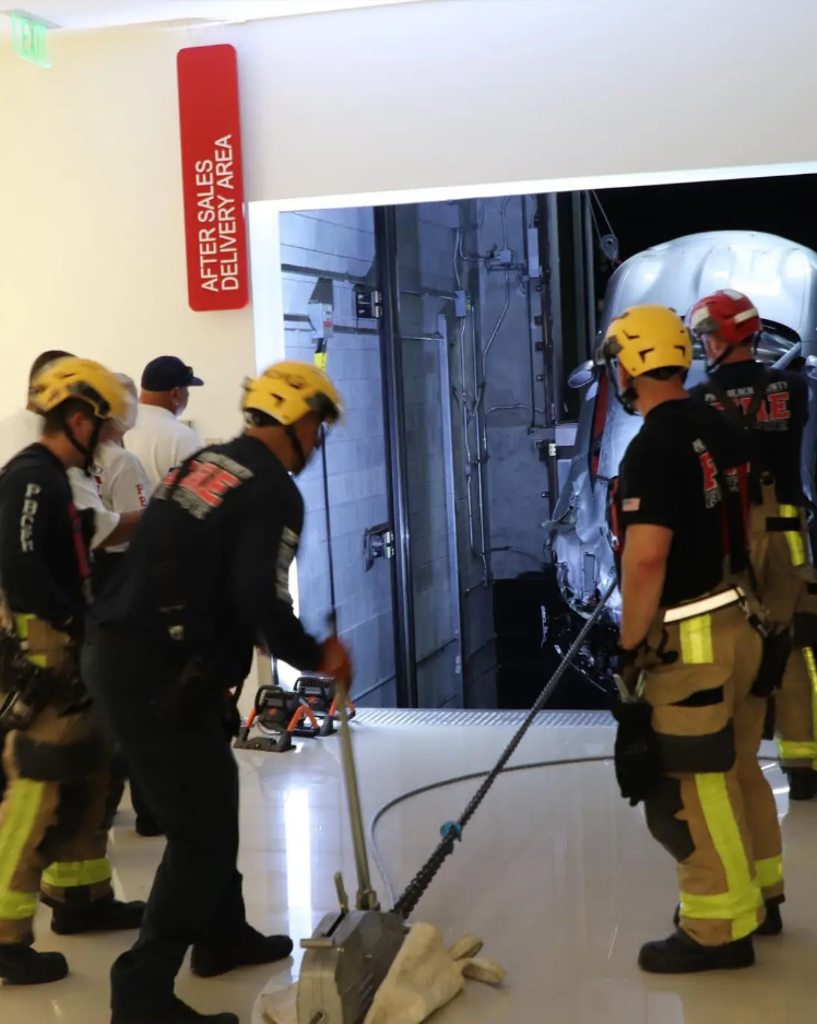 Bombeiros seguram e ajustam cabos de aço. À frente é possível ver o carro suspenso 