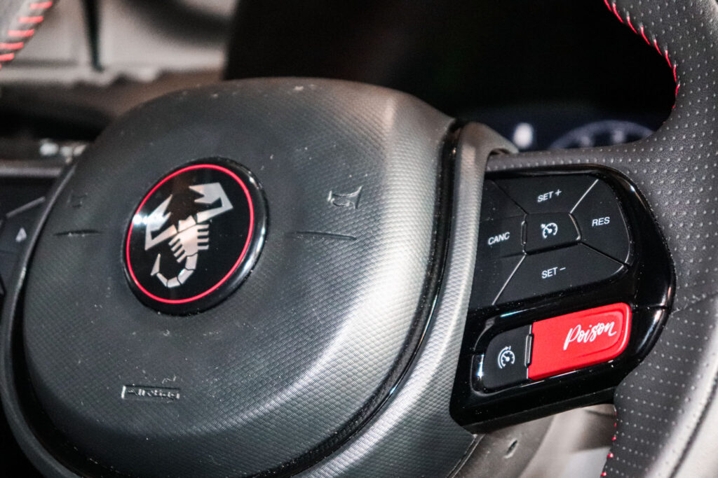 Detalhes do volante do Pulse Abarth, mostrando o escorpão no centro do volante e as teclahs multifuncionais