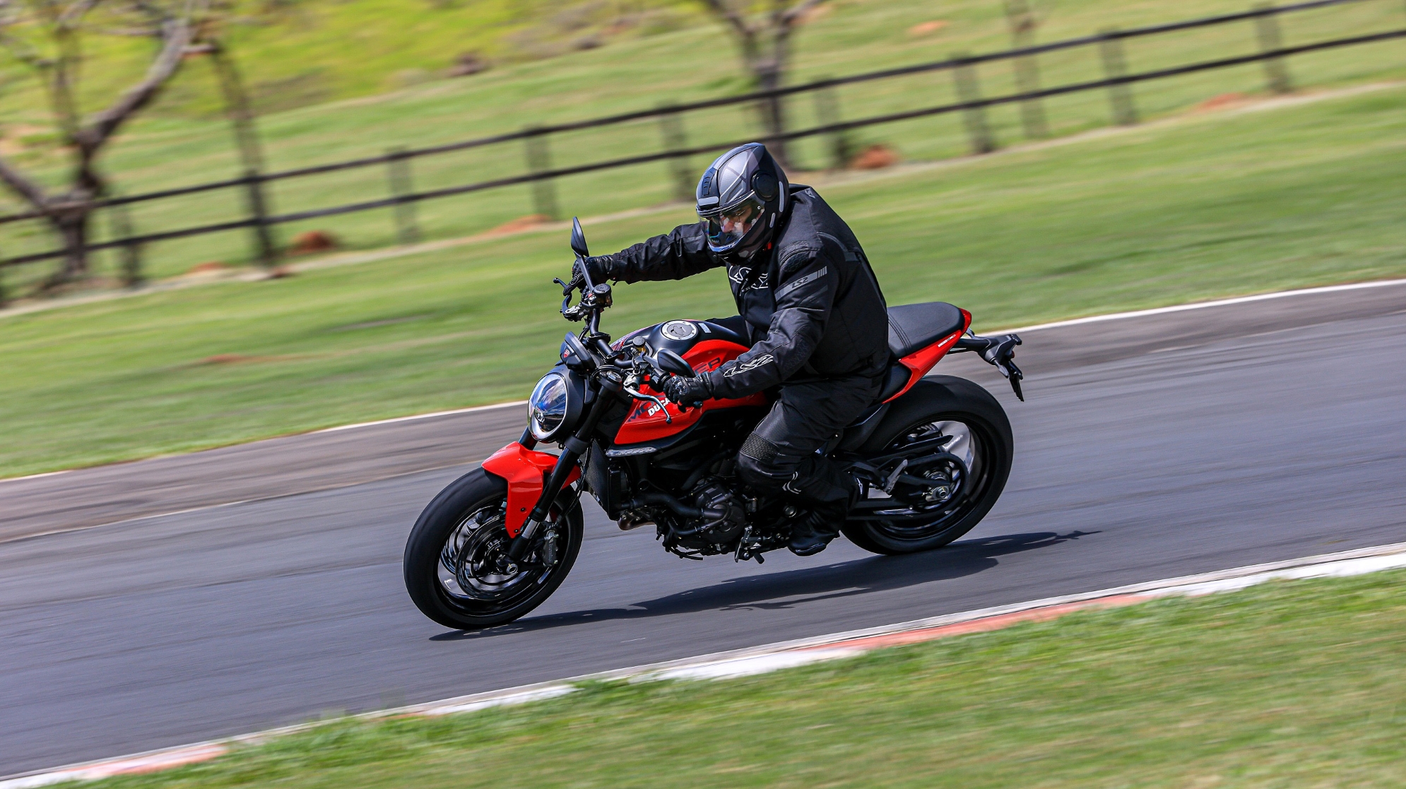 Ducati Monster 937 modelo 2023 vermelha de lateral em movimento no asfalto