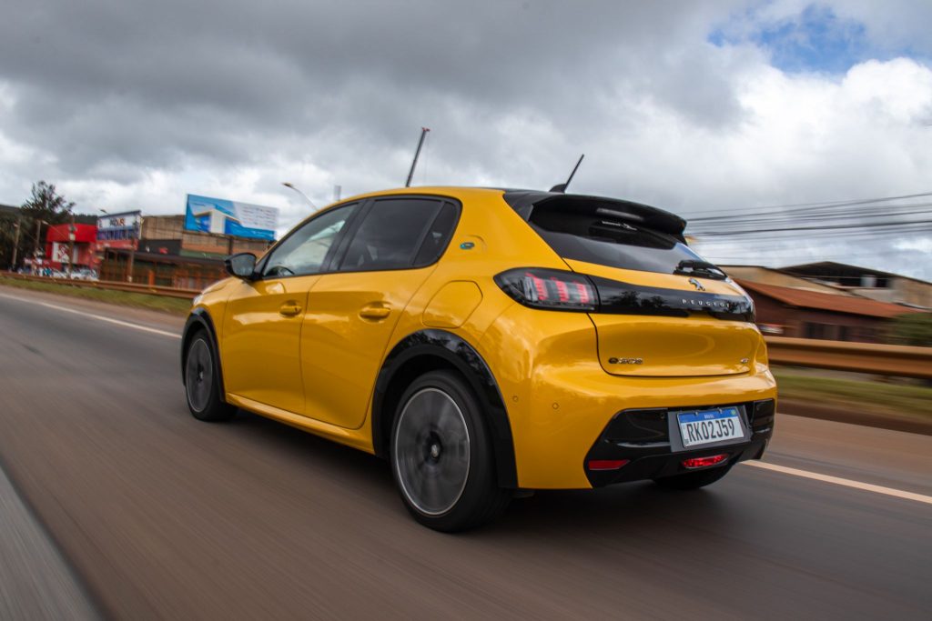 Peugeot e-208 elétrico amarelo de traseira em movimento.