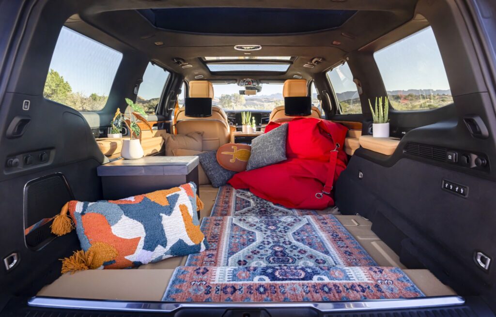 Cabine interna do Jeep Grand Wagoneer Overland com puffs, tapete e almofadas.